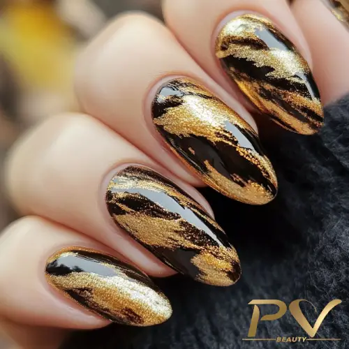 Unhas com esmalte preto e dourado, decoradas com padrão abstrato brilhante.