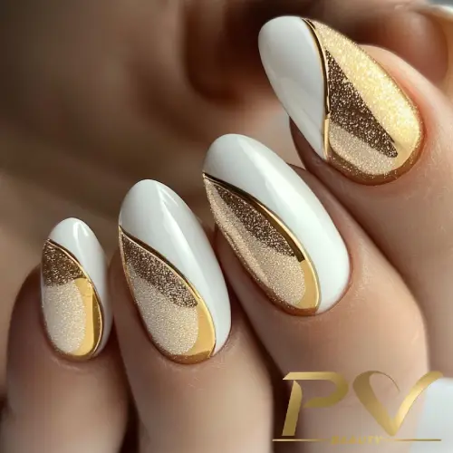 Unhas decoradas com esmalte branco, dourado e glitter, exibindo um design geométrico elegante.