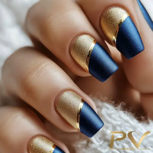 Unhas decoradas com esmalte azul e dourado, com acabamento fosco e detalhes metálicos.
