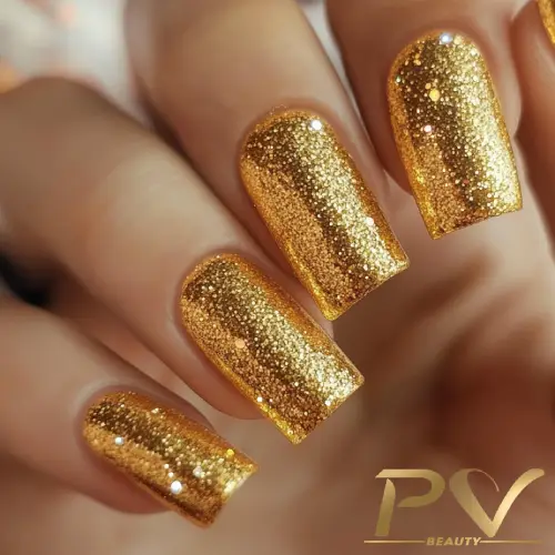 Unhas pintadas com esmalte dourado brilhante e glitter.