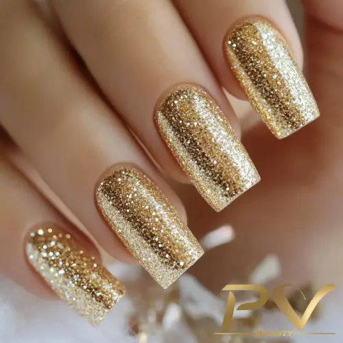 Unhas decoradas com esmalte dourado brilhante e acabamento reluzente.
