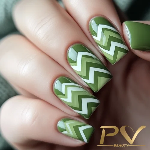 unhas-em-verde-decoradas-chevron-pv-beauty-09 Unhas decoradas com esmalte verde e padrão de zig-zag branco.