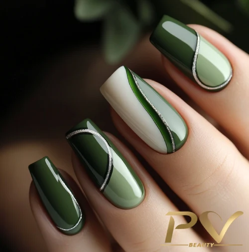 unhas-em-verde-decoradas-curvas-assimetricas-pv-beauty-11 Unhas decoradas em tons de verde com detalhes prateados e design elegante.