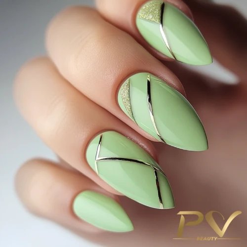 unhas-em-verde-decoradas-metais-dourados-pv-beauty-22 Unhas decoradas em verde claro com detalhes prateados e glitter em formato geométrico.