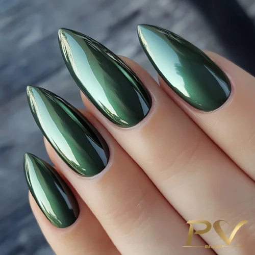 unhas-em-verde-decoradas-metalizadas-pv-beauty-07 Unhas alongadas e pontiagudas com esmalte verde metálico brilhante, capturadas em close-up.