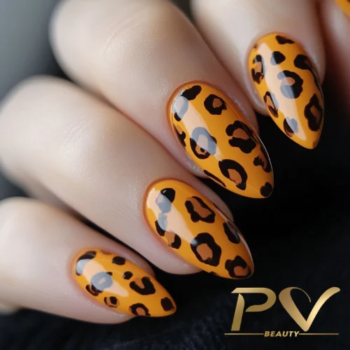 unhas-laranja-decoradas-animal-print-pv-beauty-25 Unhas com esmalte laranja e estampa de oncinha, exibindo um design elegante e moderno.