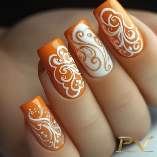 unhas-laranja-decoradas-arabescos-brancos-pv-beauty-06 Unhas laranjas com desenhos brancos detalhados e curvilíneos.