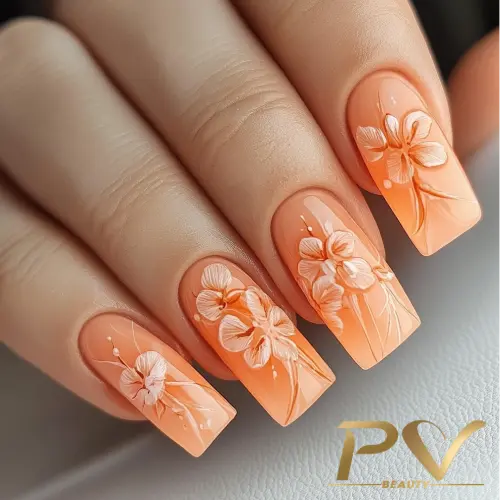 unhas-laranja-decoradas-floral-pv-beauty-12 Unhas decoradas com esmalte laranja e desenhos de flores brancas em relevo.