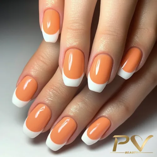 unhas-laranja-decoradas-francesinha-pv-beauty-16 Unhas com esmalte laranja e pontas brancas em uma mão sobre fundo claro.