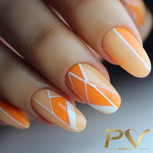 unhas-laranja-decoradas-geometricas-pv-beauty-20 Unhas decoradas com esmalte laranja e nude, com desenhos geométricos em branco, em um fundo desfocado.
