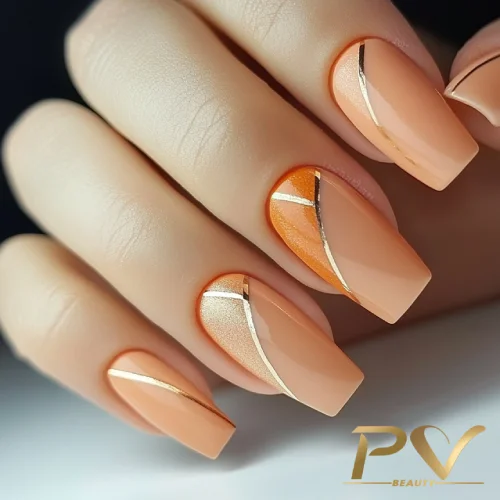 unhas-laranja-decoradas-metais-dourados-pv-beauty-22 Unhas decoradas com esmalte em tons de laranja e nude, com detalhes metálicos em dourado.