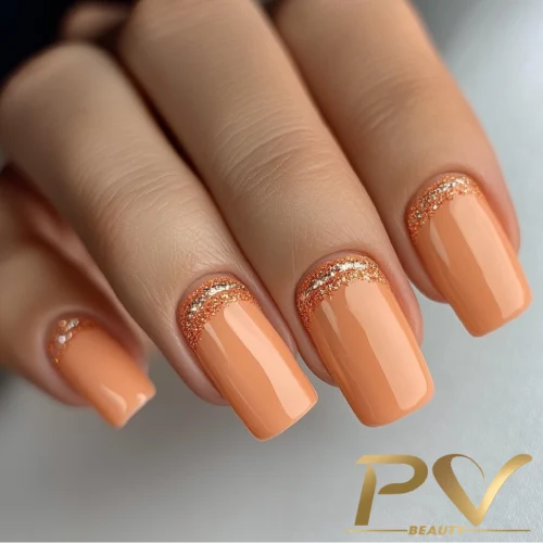 unhas-laranja-decoradas-quadradas-glitter-pv-beauty-14 Unhas pintadas de laranja com detalhes de glitter dourado próximas à cutícula.