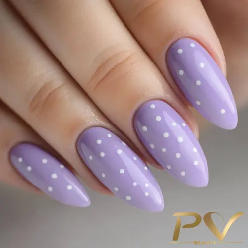Unhas com esmalte lilás e decoração de bolinhas brancas em formato oval.
