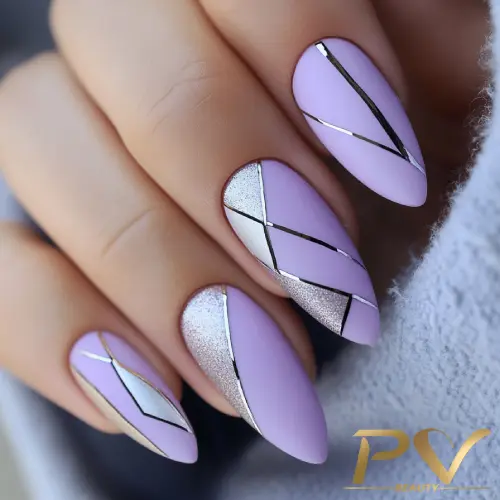 Unhas com esmalte lilás e detalhes geométricos prateados e brilhantes.