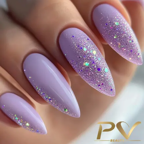 Unhas em formato stiletto pintadas de lilás com glitter brilhante.