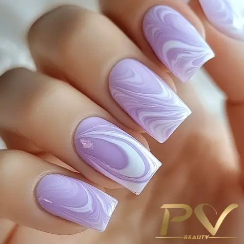 Unhas com esmalte lilás e design marmorizado em close-up.