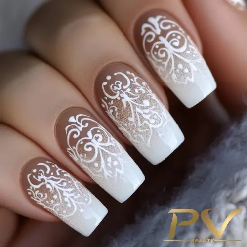 unhas-marrons-arabescos-ombre-decoradas-pv-beauty-13 Unhas decoradas com esmalte branco em design floral detalhado sobre base nude.