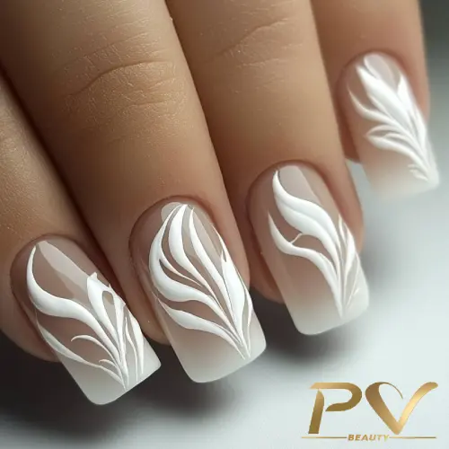 unhas-marrons-decoradas-arte-criativa-pv-beauty-15 Unhas decoradas com esmalte branco, exibindo um design artístico de linhas curvas sobre um fundo neutro.