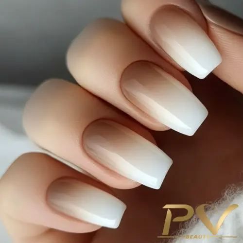 unhas-marrons-decoradas-babyboom-perfeito-pv-beauty-24 Mão com unhas compridas e quadradas, esmaltadas em tons de branco degradê.