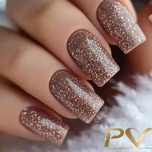 unhas-marrons-decoradas-glitter-brilho-pv-beauty-34 Unhas com esmalte marrom brilhante e glitter, exibindo um acabamento reluzente. Logotipo "PV Beauty" no canto.