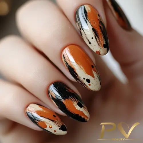 unhas-marrons-decoradas-pinceladas-artisticas-pv-beauty-19 Unhas decoradas com esmalte em tons de laranja, preto e bege, exibindo um design artístico abstrato.