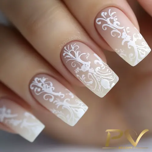 unhas-nude-arabescos-suaves-decoradas-pv-beauty-09 Unhas decoradas com esmalte nude e desenhos brancos intricados em estilo floral.