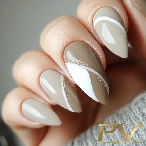 unhas-nude-curvas-chiques-decoradas-pv-beauty-20 Mãos com unhas alongadas, decoradas com esmalte bege e branco, exibindo um design geométrico elegante.