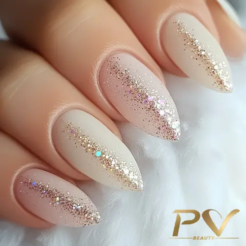 unhas-nude-decoradas-designer-de-unhas-pv-beauty-01 Unhas com esmalte nude e glitter dourado em degradê sobre fundo claro.