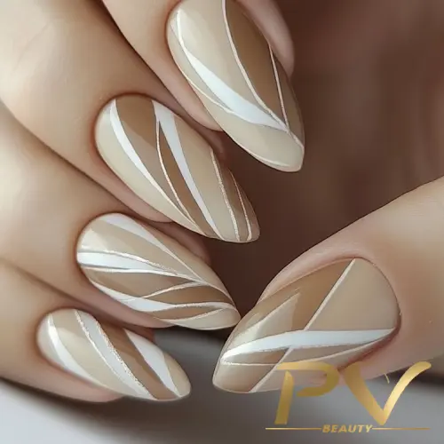 unhas-nude-decoradas-formas-perfeitas-pv-beauty-21 Unhas decoradas com esmalte nude e linhas brancas formando padrões geométricos.