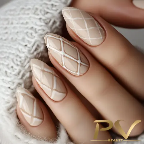 unhas-nude-decoradas-losangos-belissimos-pv-beauty-06 Unhas decoradas com esmalte nude e desenhos geométricos em branco sobre tecido de lã claro.