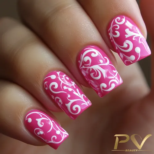 unhas-pink-decoradas-arabescos-pv-beauty-18 Unhas decoradas com esmalte rosa e desenhos brancos em padrão floral.