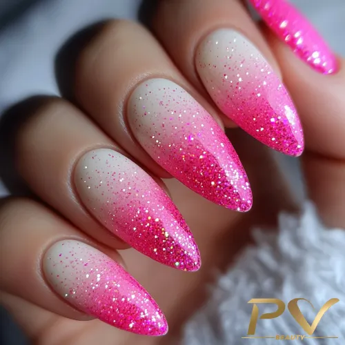 unhas-pink-decoradas-designer-de-unhas-pv-beauty-01 Unhas longas com esmalte degradê rosa e glitter, em close, sobre fundo neutro.