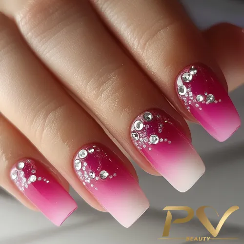 unhas-pink-pedrarias-decoradas-pv-beauty-07 Unhas com esmalte rosa e branco em degradê, decoradas com pedras brilhantes e detalhes prateados.