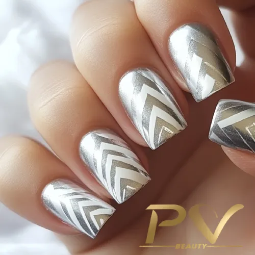 unhas-prata-chevron-decoradas-pv-beauty-12 Unhas com esmalte prateado e padrão geométrico em zigue-zague.