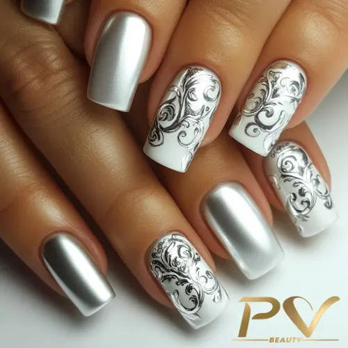unhas-prata-decoradas-arabescos-pv-beauty-02 Unhas decoradas com esmalte prateado e detalhes florais em preto sobre fundo branco.
