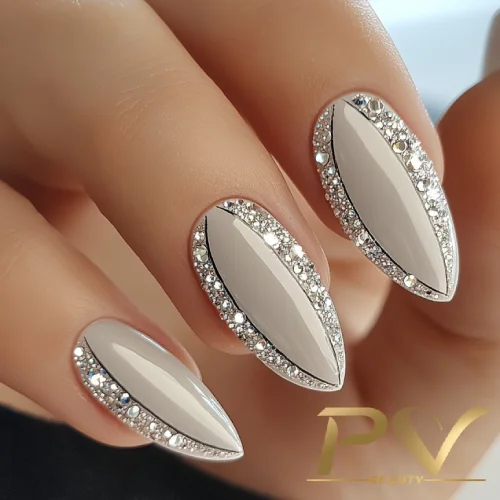 unhas-prata-decoradas-strass-pv-beauty-03 Unhas decoradas em formato amendoado com esmalte nude, contorno preto e aplicação de pequenas pedrinhas brilhantes.