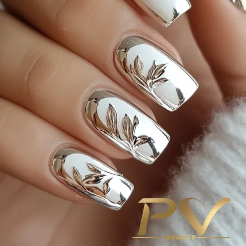 unhas-prata-florais-decoradas-pv-beauty-18 Unhas espelhadas prateadas com desenhos de folhas.