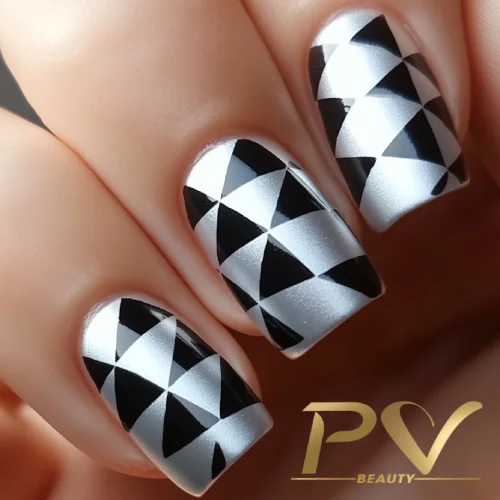 unhas-prata-geometricas-decoradas-pv-beauty-20 Unhas decoradas com padrão geométrico em preto e branco, formando triângulos simétricos.