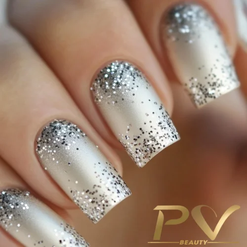unhas-prata-glitter-decoradas-pv-beauty-21 Unhas com esmalte prateado fosco e glitter nos cantos, criando um efeito degradê elegante.