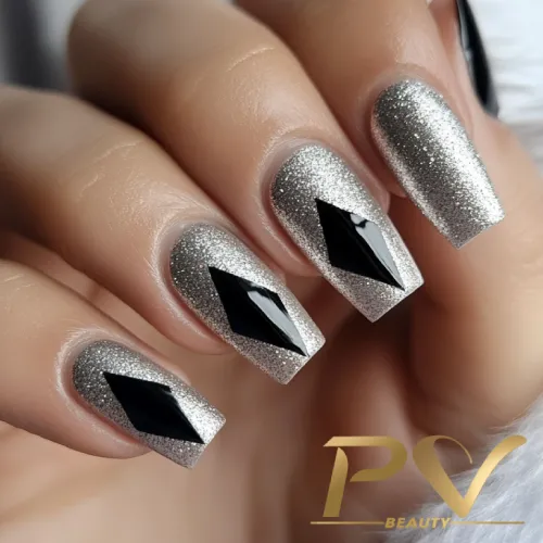 unhas-prata-losangos-decoradas-pv-beauty-31 Unhas com esmalte prateado brilhante e detalhes geométricos pretos aplicados no centro de cada unha.