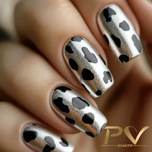 unhas-prata-oncinha-animal-print-decoradas-pv-beauty-14 Unhas decoradas com esmalte metálico prateado e manchas pretas em padrão irregular.