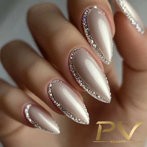 unhas-prata-strass-decoradas-pv-beauty-11 Unhas longas e pontiagudas com esmalte nude e bordas decoradas com pequenos cristais brilhantes.