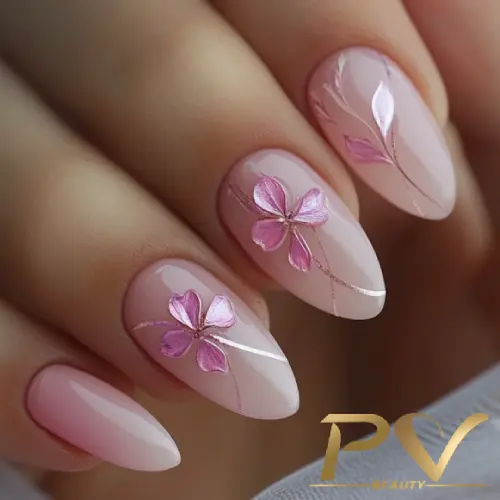 Unhas decoradas com esmalte rosa claro e desenho de flores em relevo, destacando detalhes delicados.