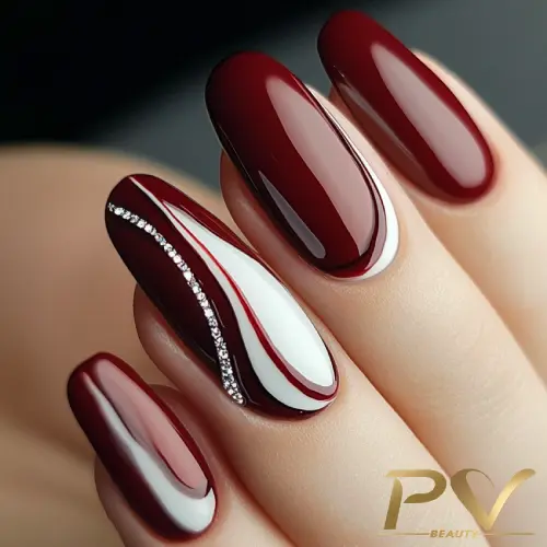 unhas-vinho-decoradas-curvas-arte-linda-pv-beauty-16 Unhas decoradas com esmalte vermelho escuro e detalhes em branco e strass.
