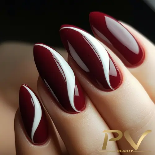 unhas-vinho-decoradas-curvas-brancas-pv-beauty-35 Unhas decoradas em vermelho e branco com design de linhas curvas.
