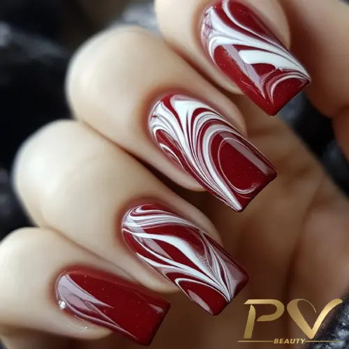 unhas-vinho-decoradas-marmorizadas-pv-beauty-27 Unhas decoradas com esmalte vermelho e branco em design marmorizado, mostrando detalhes artísticos e elegantes.