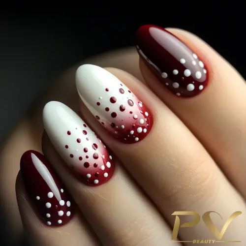 unhas-vinho-degrade-poa-decoradas-pv-beauty-32 Unhas com esmalte vermelho e branco, decoradas com pequenos pontos brancos, em um fundo neutro.