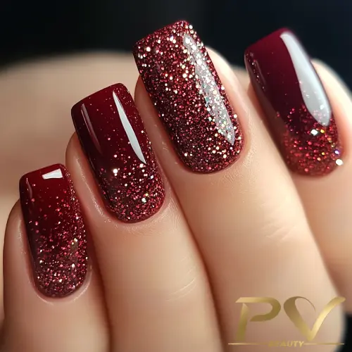 unhas-vinho-glitter-decoradas-pv-beauty-09 Unhas pintadas de vermelho escuro com glitter, exibindo um acabamento brilhante e elegante.