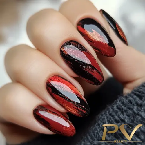 unhas-vinho-pinceladas-arte-moderna-decoradas-pv-beauty-11 Unhas com esmalte vermelho e preto, efeito marmorizado, em uma mão segurando tecido escuro.