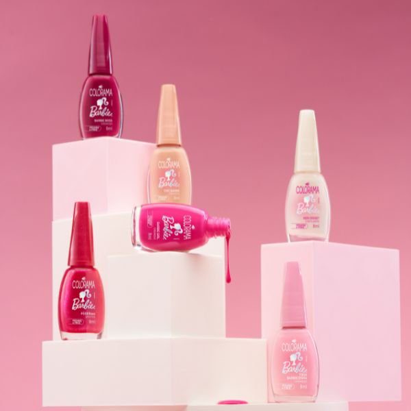 esmaltes-colorama-barbie Foto da Coleção Barbie™ + Colorama com os esmaltes posicionados em uma estrutura branca em fundo rosa.